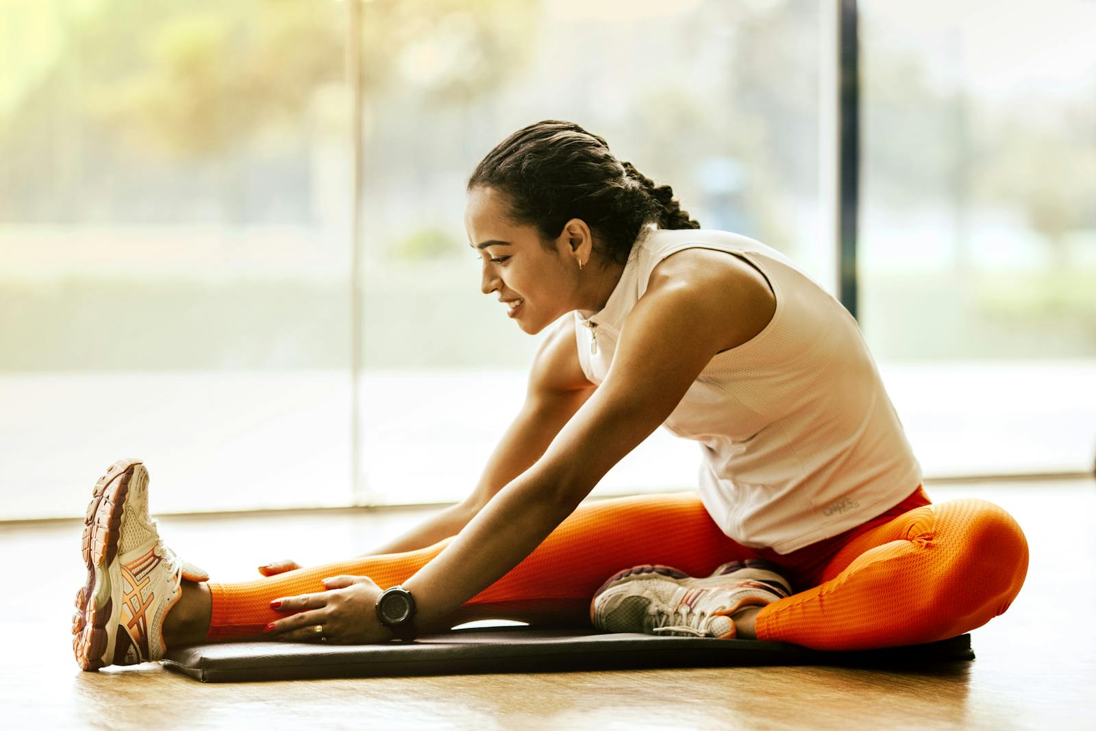 A woman enjoying a yoga pnf stretch indoors, promoting a healthy lifestyle.